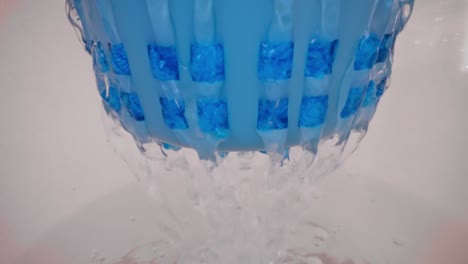 Drying-and-rinsing-of-blue-microfibre-mop-in-bucket