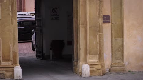 a police officer walks past historic stone arches in tuscany, italy