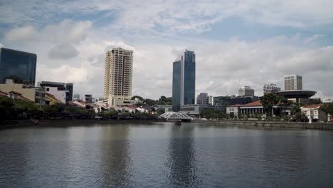 the clean singapore river with skyscrapers and various commercial buildings in singapore - push in shot