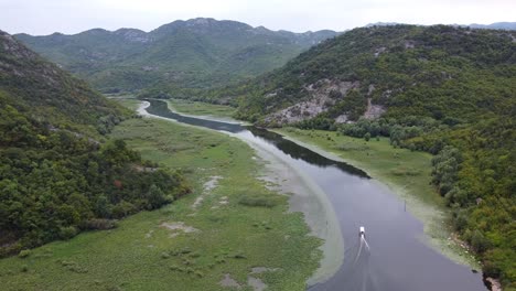 boat sails over crnojevica river and lake skader at pavlova strana viewpoint, montenegro - aerial dolly