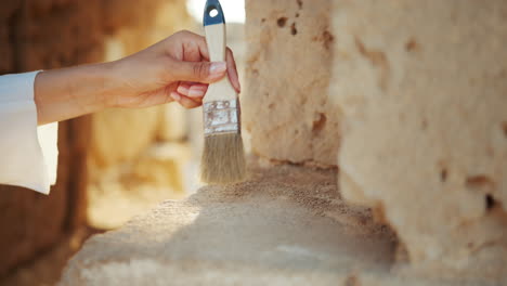 arqueólogo limpiando piedra antigua