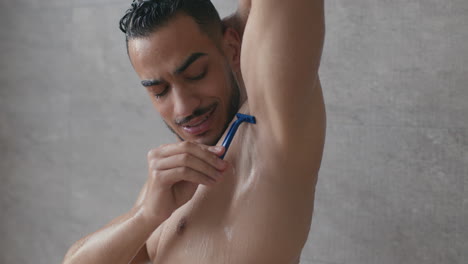 man shaving underarm in the shower