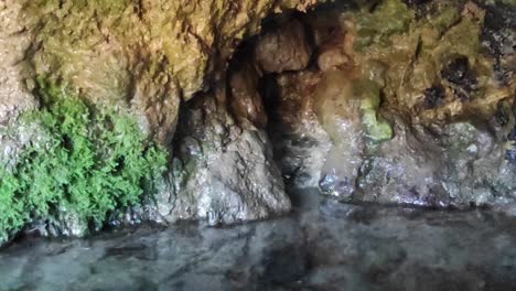 Crystal-clear-water-cascades-from-the-rocks,-forming-a-serene-interior-water-source,-a-mesmerizing-testament-to-nature's-beauty-and-tranquility