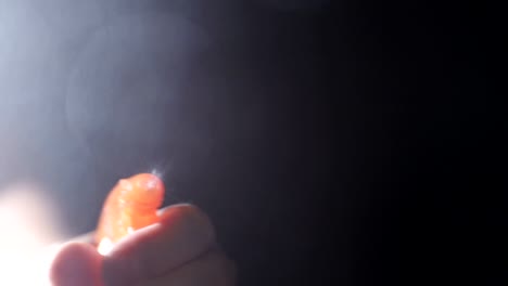close up of washing window using spray bottle and white cloth to wipe glass
