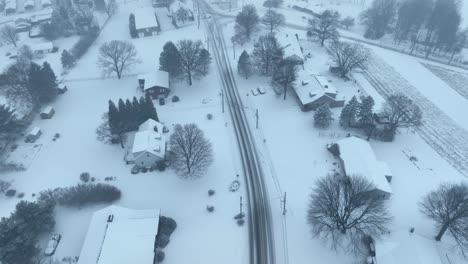 aerial birds eye shot over snow covered village in america