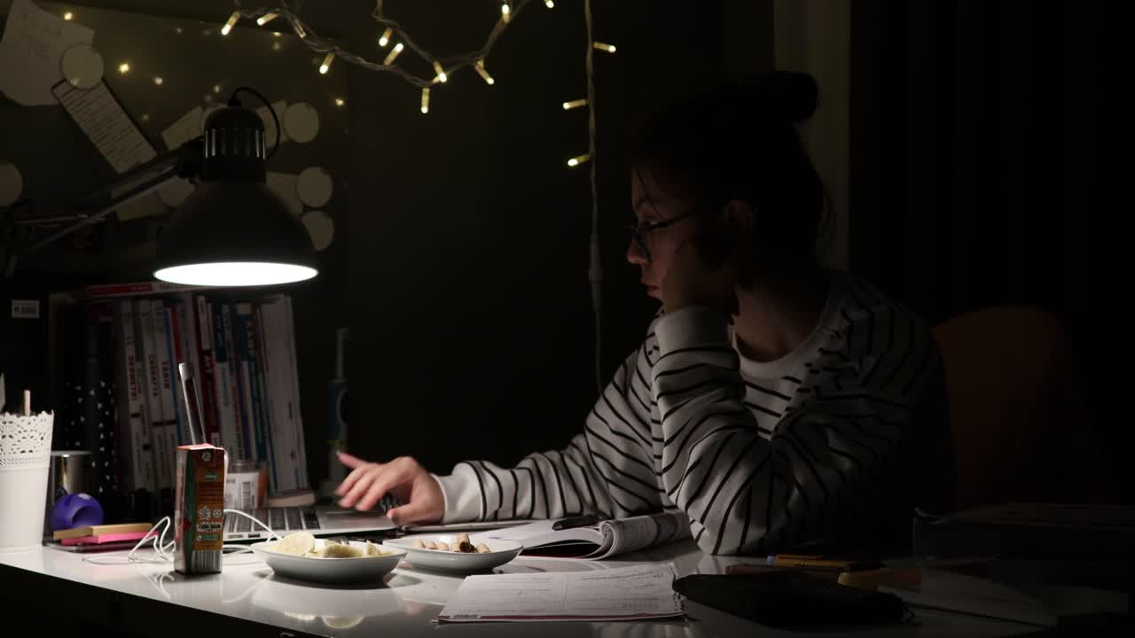 Studente che studia per l'esame alla scrivania.