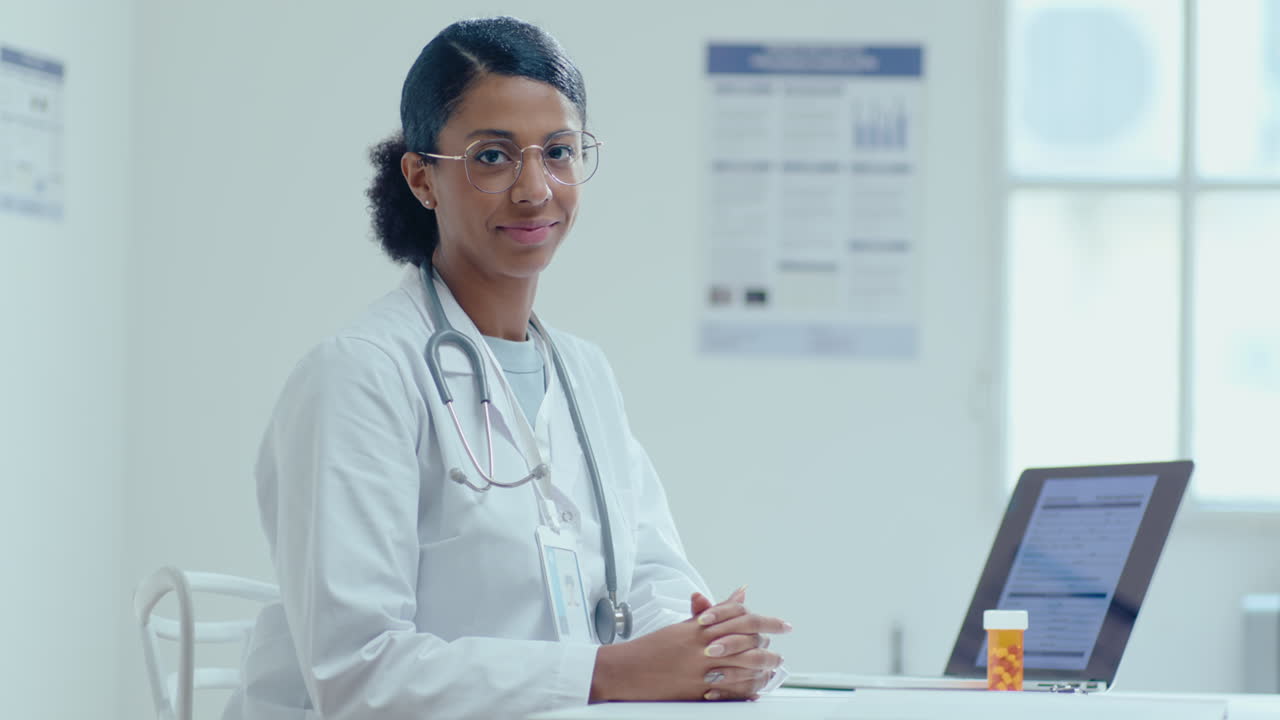 Portrait of Young Black Female Doctor at Workplace in Clinic
