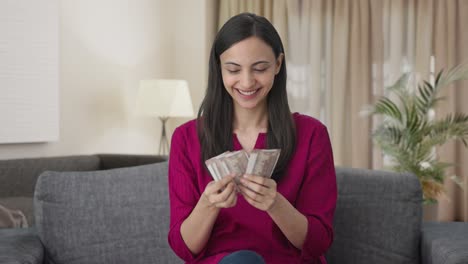 happy indian woman counting money