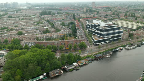 contemporary building of rivierstaete business center in amsterdam-zuid borough surrounded by the public structures close to the amstel river in amsterdam, netherlands