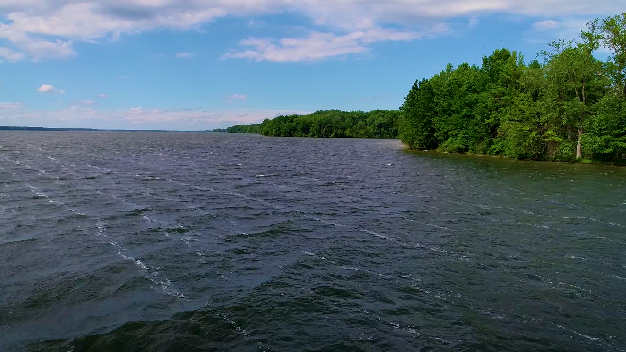 Droneoptagelser af Mosquito Lakes kystlinje på en klar dag med blå himmel og hvide skyer.