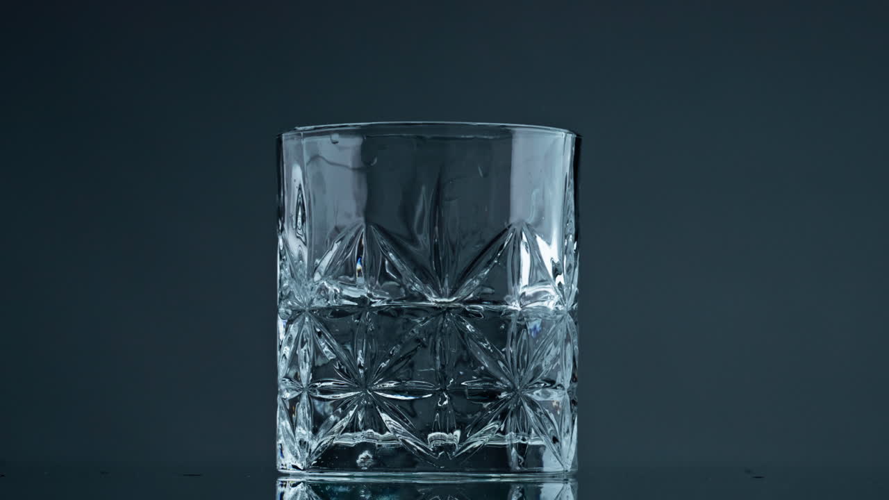 vidrio líquido de agua ondulante en primer plano de fondo oscuro. salpicaduras de fluidos minerales