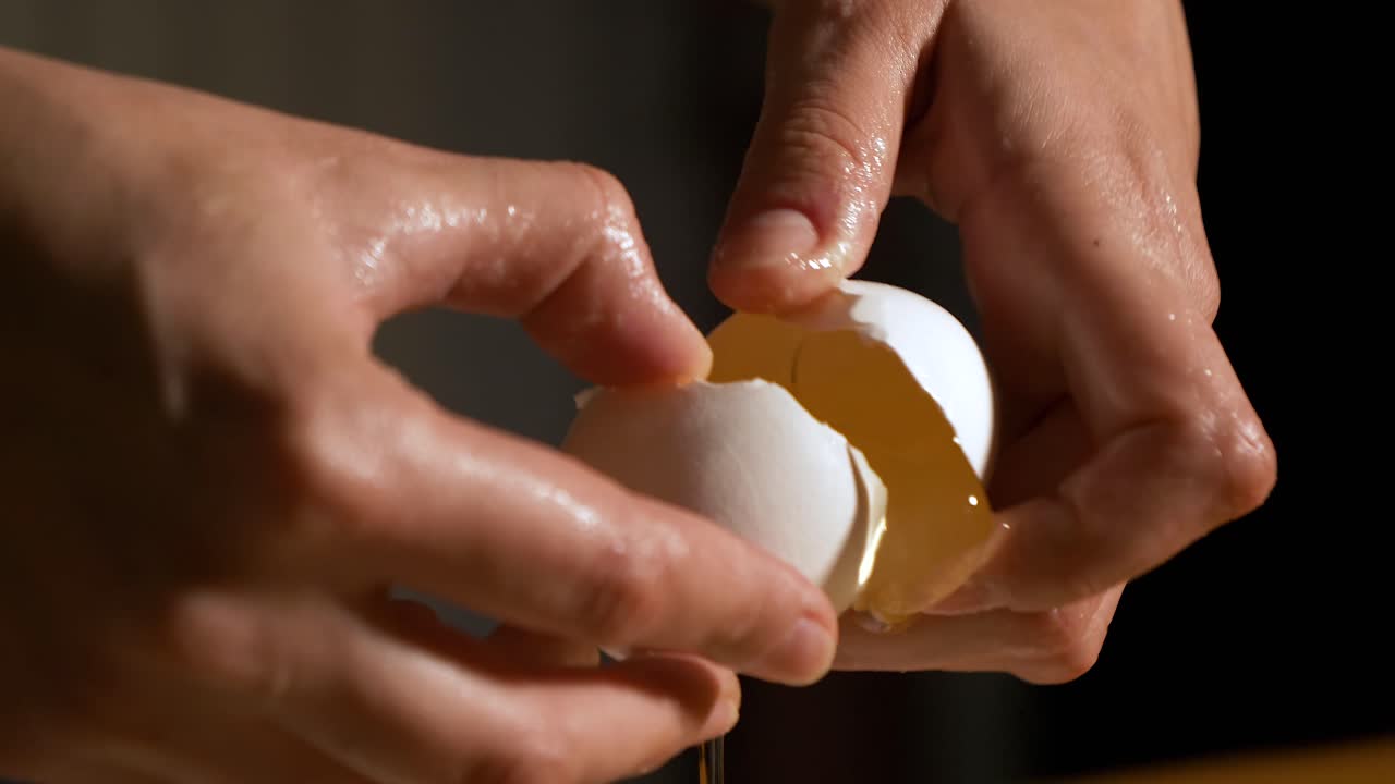 4K close up slow motion shot craked white fresh egg with a silver spoon