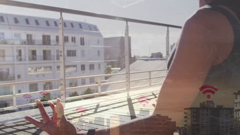 person meditating on balcony with cityscape and wi-fi signal animation overlay