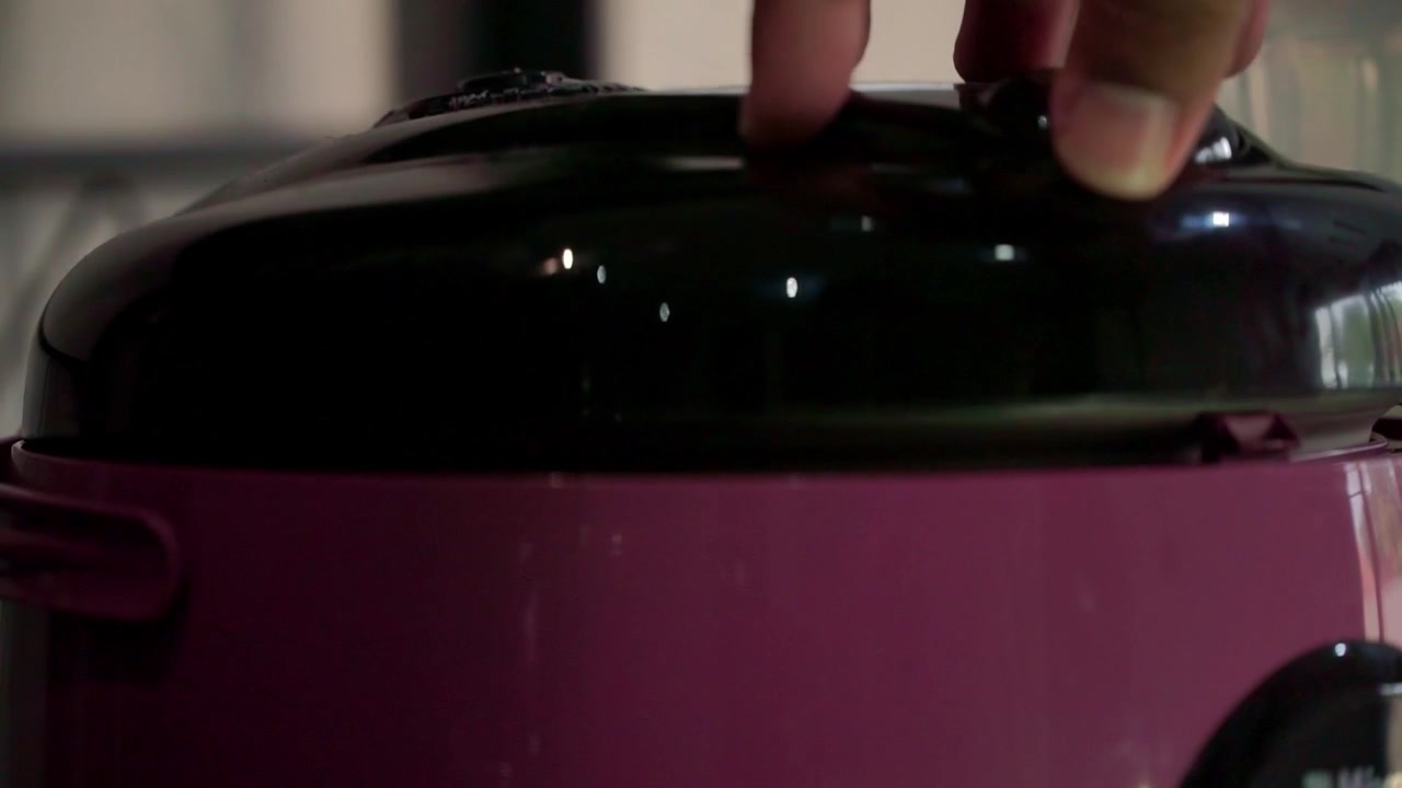 hand closing rice cooker lid before cooking. Kitchen appliance operation, home cooking preparation, culinary stock footage.