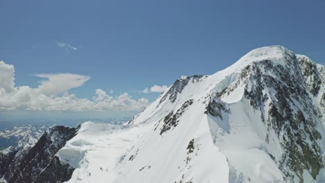 high altitude panorama, great snow mountain shines against clouds at blue sky