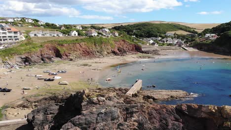 Aerial-View-Over-Sea-Stack-And-Breakwater-With-View-Of-Beach-At-Low-Tide-At-Hope-Cove-In-Devon