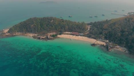 boats-sail-along-narrow-sand-coast-surrounded-by-ocean