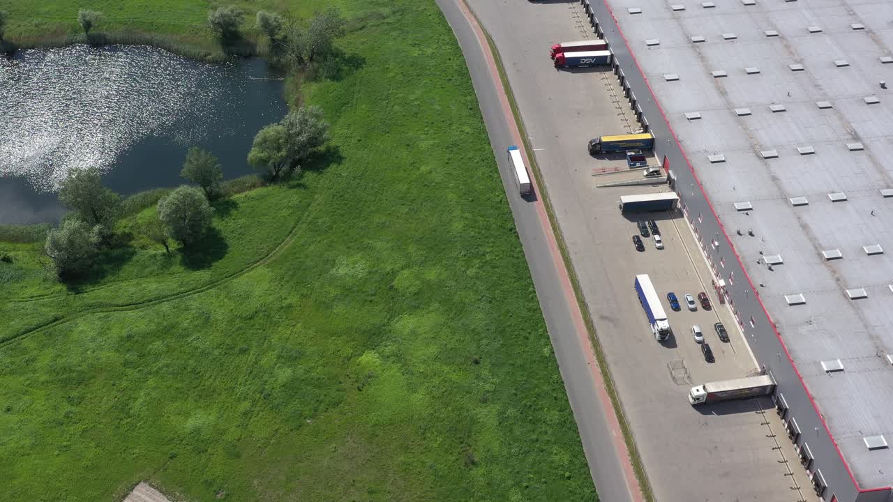foto aérea de caminhão com semi-reboque anexado saindo do complexo de armazéns
