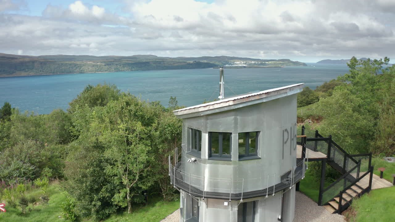 rotación aérea: una pequeña casa de lámina de aluminio junto al sonido de mull, escocia
