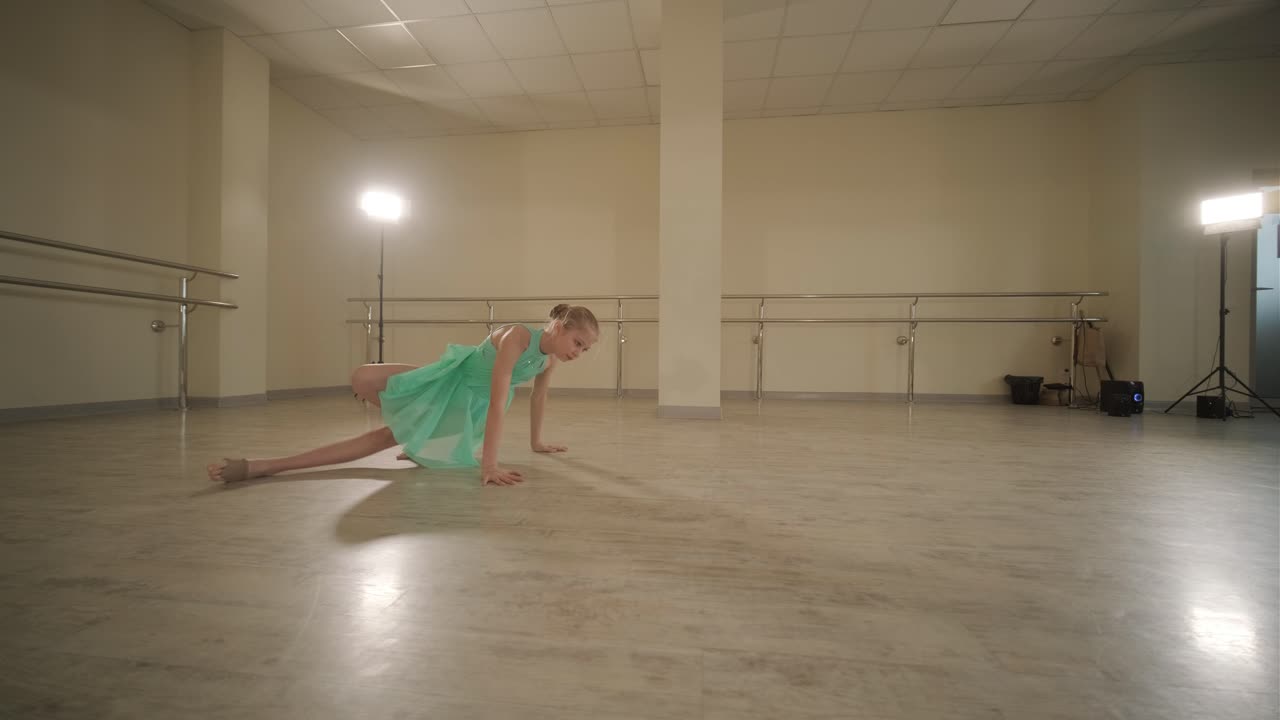 un grupo de jóvenes estudiantes de ballet con ropa de baile negra practicando posiciones en un amplio estudio de ballet con pisos de madera y barras montadas en la pared. expresiones enfocadas y movimientos sincronizados.
