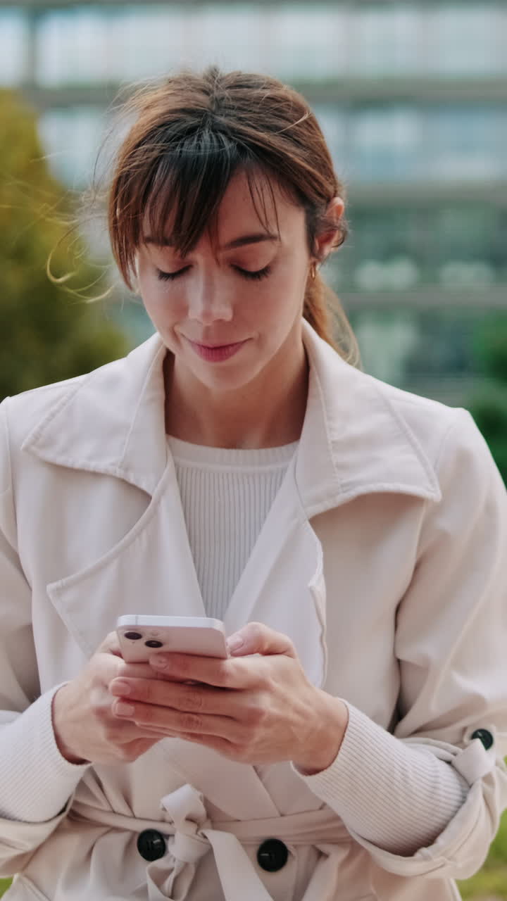 Giovane donna che manda messaggi sullo smartphone all'aperto