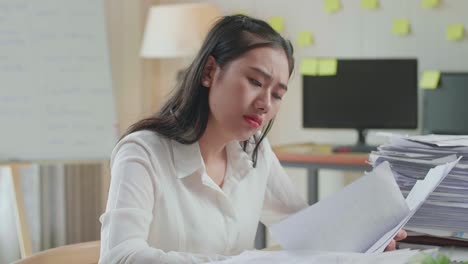 close up of tired asian woman yawning before sleeping while working hard with documents at the office
