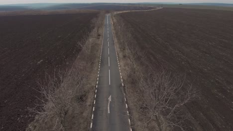 drone ascends over empty asphalt road in the middle of nowhere