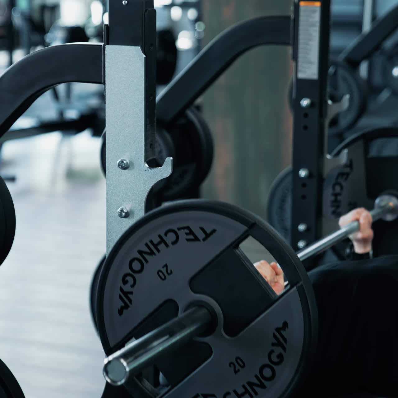 Bodybuilder Doing Barbell Exercise. Young man flexing muscles with barbell in the gym