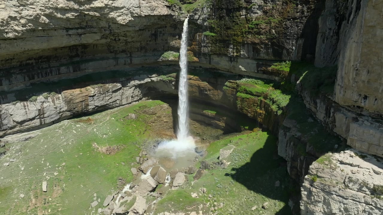 Imagens aéreas da Cachoeira Tobot caindo do Planalto de Khunzakh em um cânion rochoso com encostas verdes, República do Daguestão, Rússia