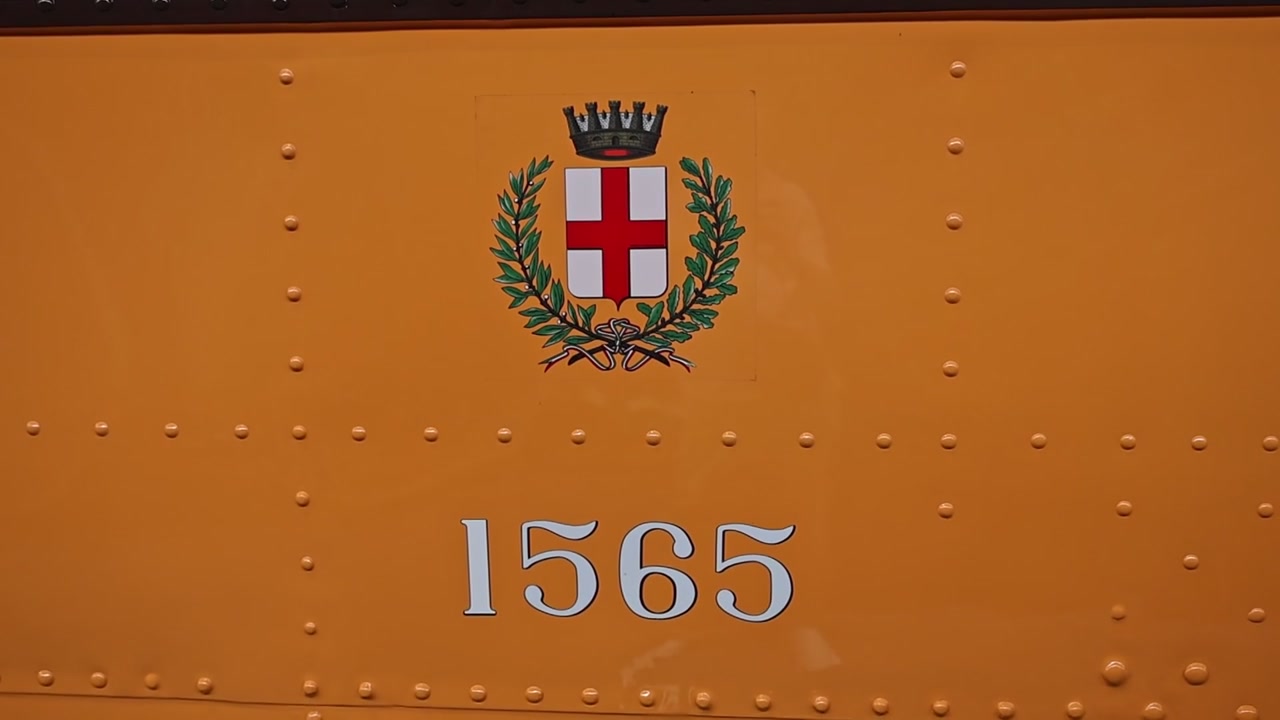 Primo piano di un tram giallo d'epoca con l'emblema della città di Milano