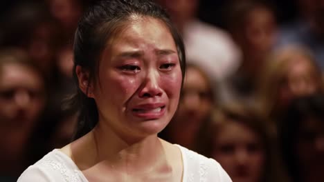 a poignant moment captured, revealing deep emotion and vulnerability in the face of distress, showcasing the raw human experience amidst a supportive crowd