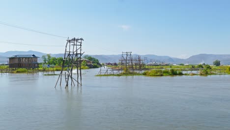 boats float between stilted houses on inle lake
