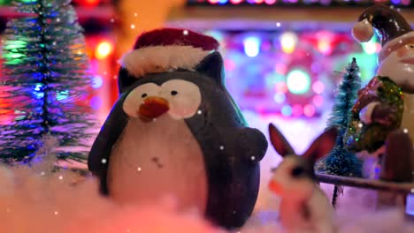 primer plano deslizante de una decoración navideña con un papá noel y divertidos pingüinos con un gorro navideño