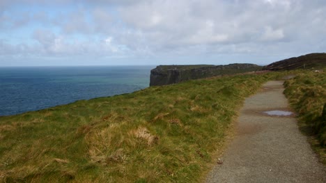 extra wide shot of coastal path looking at tintagel cliffs in background, from lower penhallic tregatta