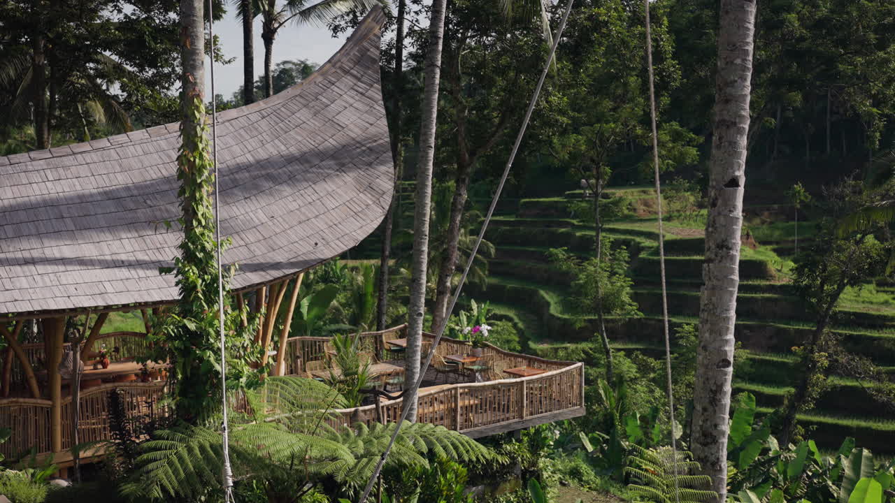 área de comedor adornada con decoración tradicional balinesa y rodeada de follaje tropical
