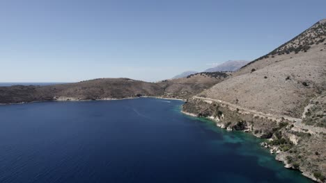 video de drones sobre las aguas turquesas de la costa albanesa en porto palermo, se puede ver un búnker submarino de la segunda guerra mundial y un barco navegando