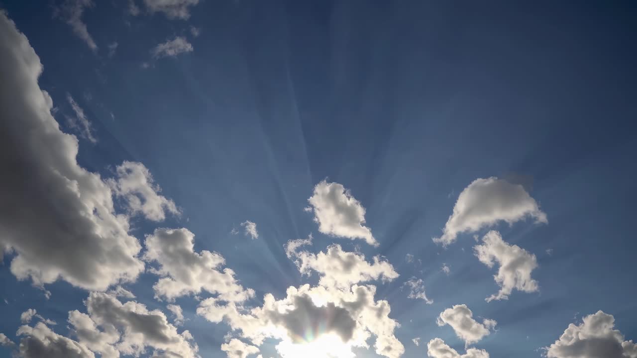 Time-lapse video of clouds with sun rays, captured from a low-angle, creating a dynamic and serene
