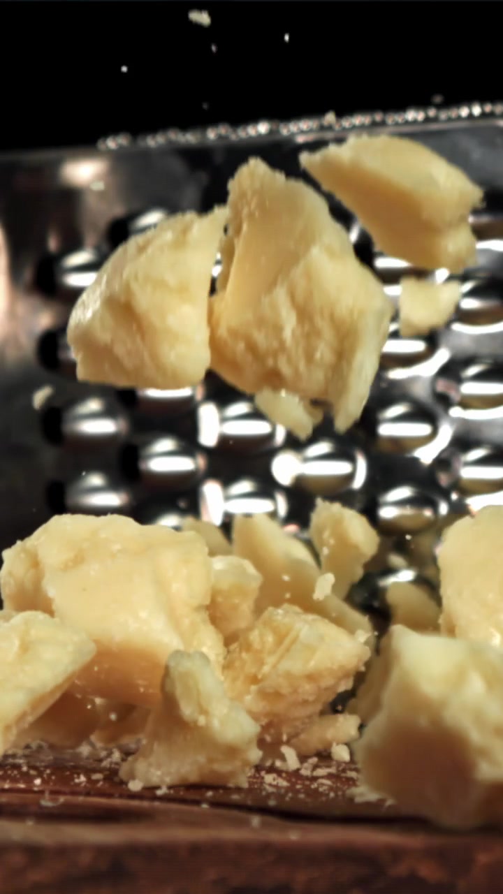 Pezzi di Parmigiano che cadono al rallentatore.
