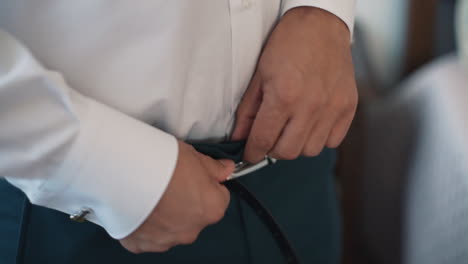 detail of man fastening a belt