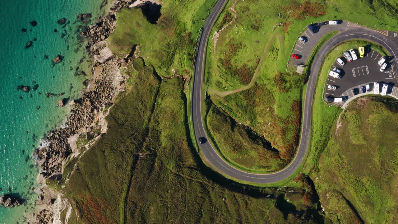 Aerial top down view of winding S shaped road and parking lot at Keem Beach on Achill Island in Ireland