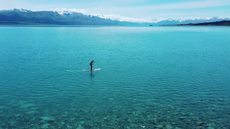 abenteuerlustige gelassenheit: paddelboarder mit mount cook als hintergrund in fesselnden stock-aufnahmen