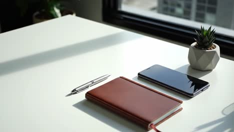 a minimalist desk scene with a notebook, phone, and succulent plant, illustrating a calm workspace design for productivity and inspiration