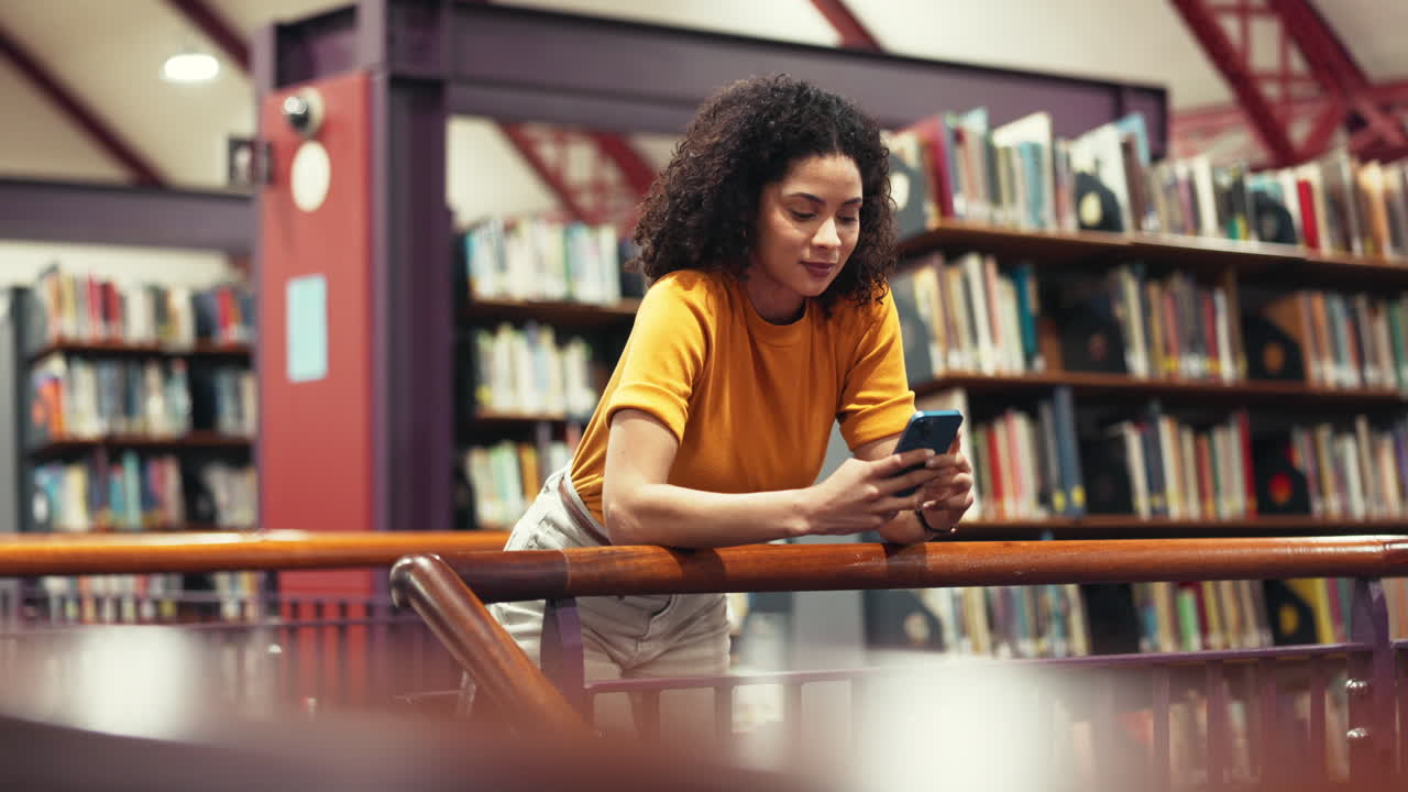 Femme utilisant un téléphone portable dans une bibliothèque