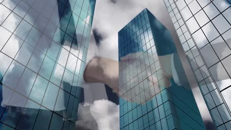 mid section of businessman and businesswoman shaking hands against tall buildings in background