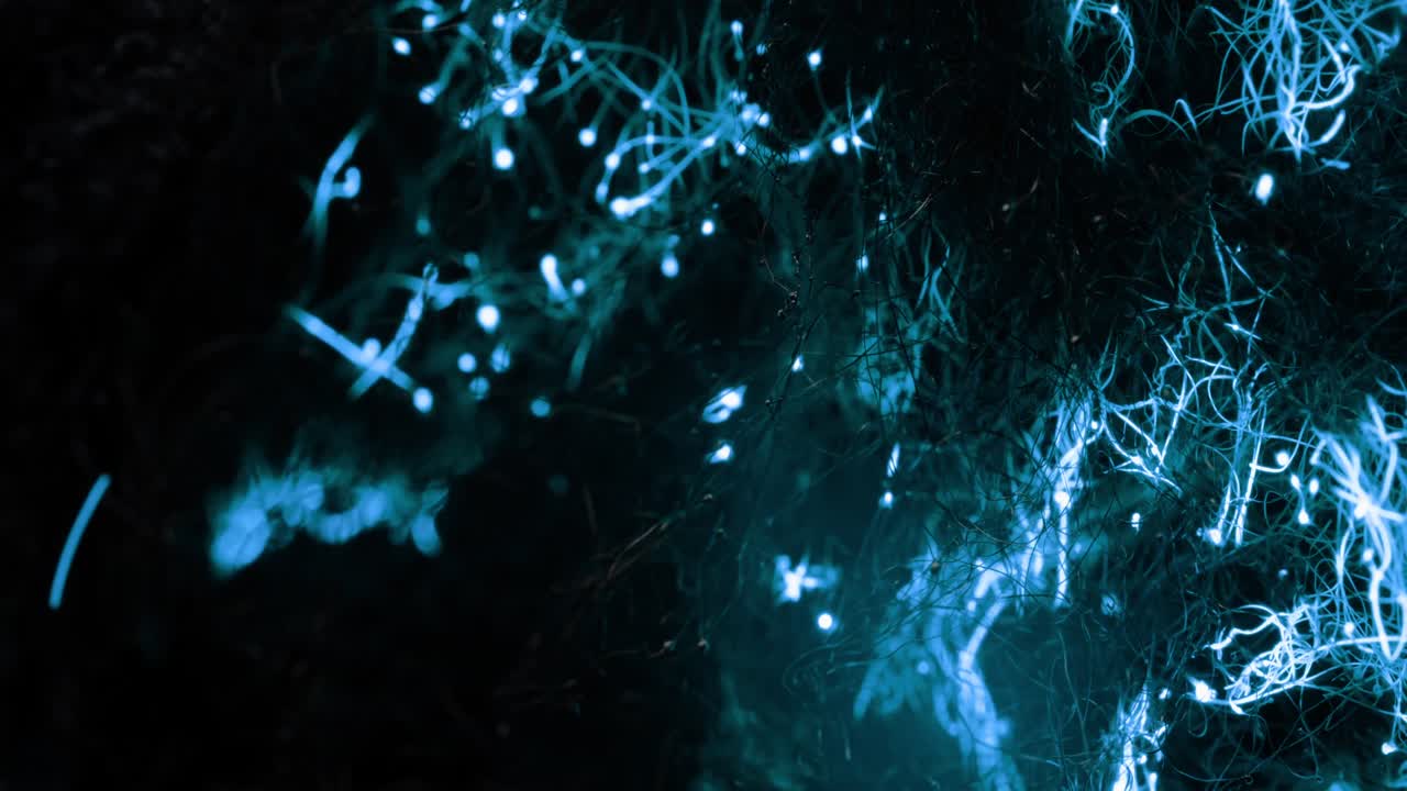 la energía azul gira en una red oscura abstracta y forma nubes que emiten un resplandor azul repetidamente.