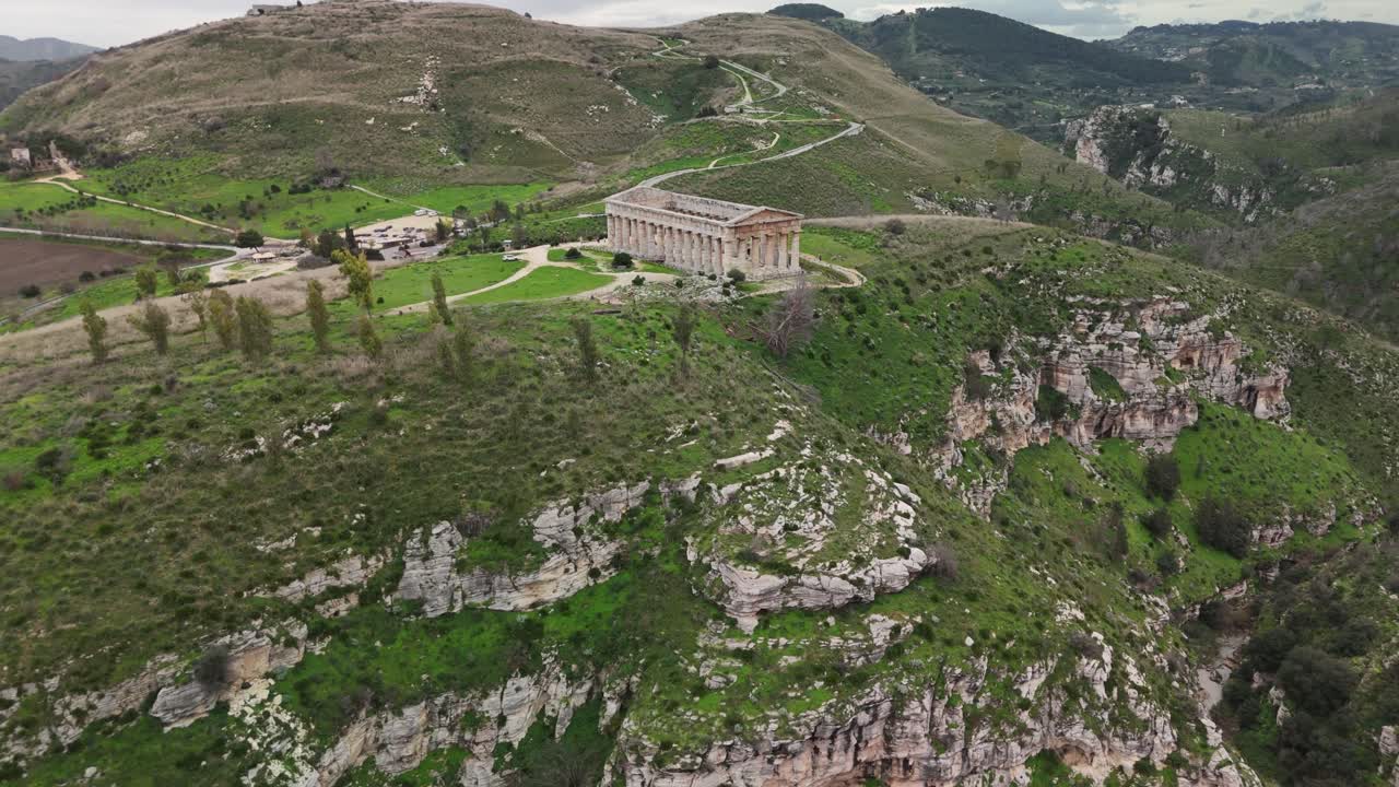 Vista aerea con drone di un antico tempio su una collina con paesaggio aspro e cielo nuvoloso