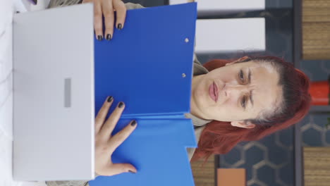 vertical video of angry business woman angrily closes files.