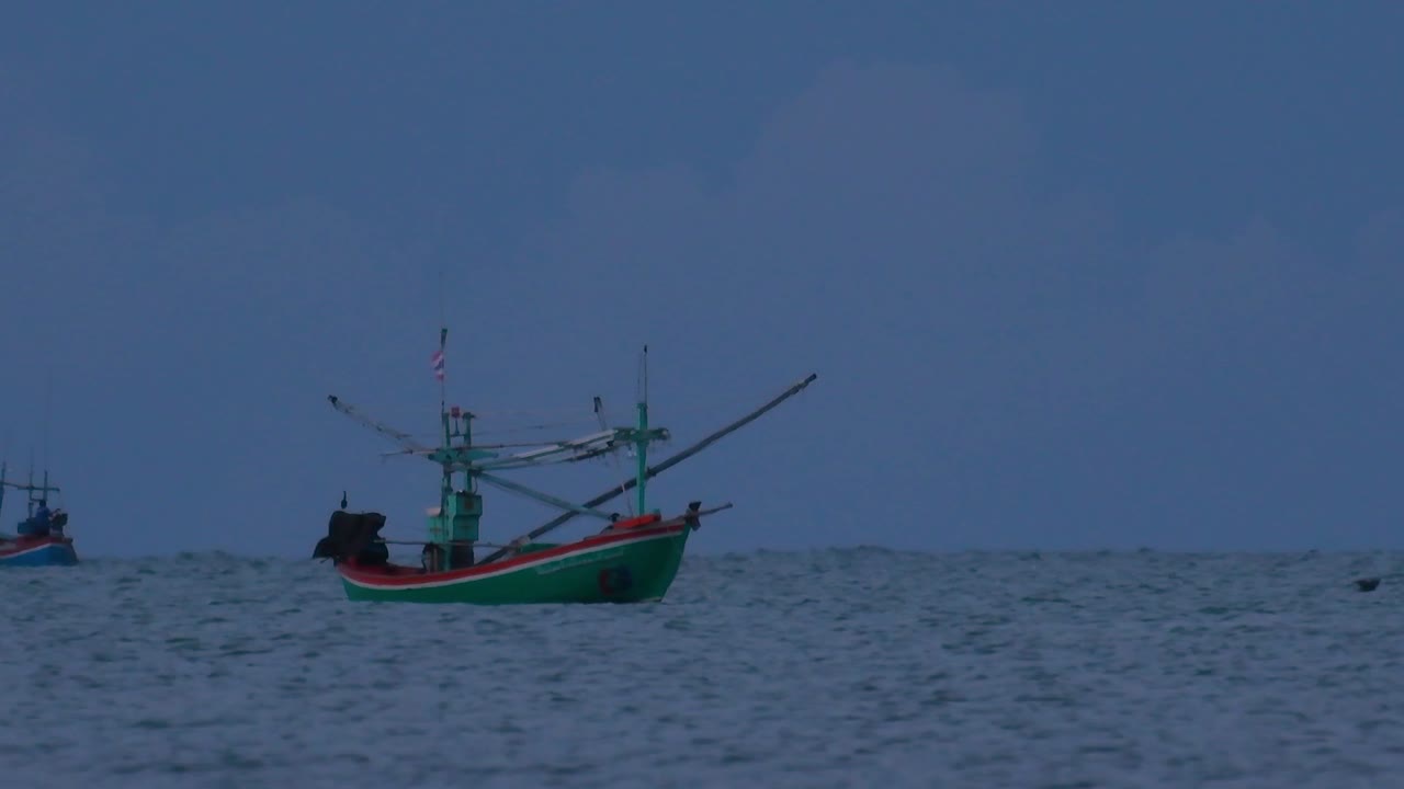 태국의 어선은 바다 한가운데서 어두워지기를 기다리며 초록불을 켜고 낚시를 시작하고 새우를 잡습니다.