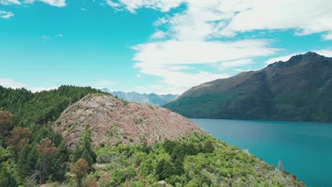 Zumbido-Del-Lago-Que-Se-Revela-Detrás-De-La-Montaña-De-Nueva-Zelanda