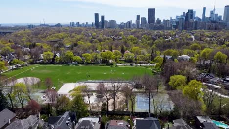 Aerial-view-orbiting-Toronto-park-with-a-baseball-field-on-a-spring-day